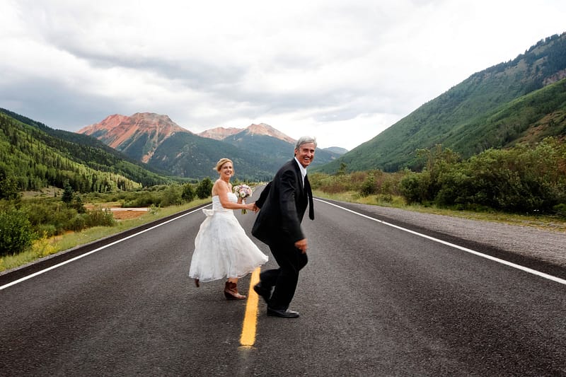bride and groom crossing the road in ouray colorado