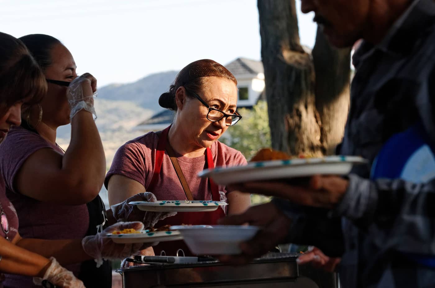volunteers serve dinner to migrant workers