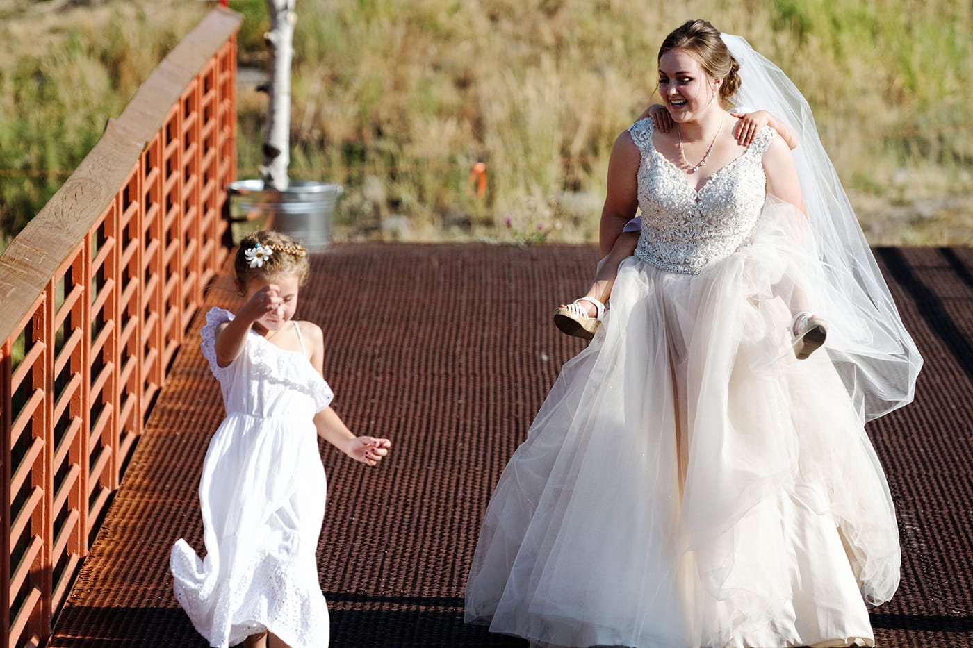 bride giving the flowergirl a piggy back ride