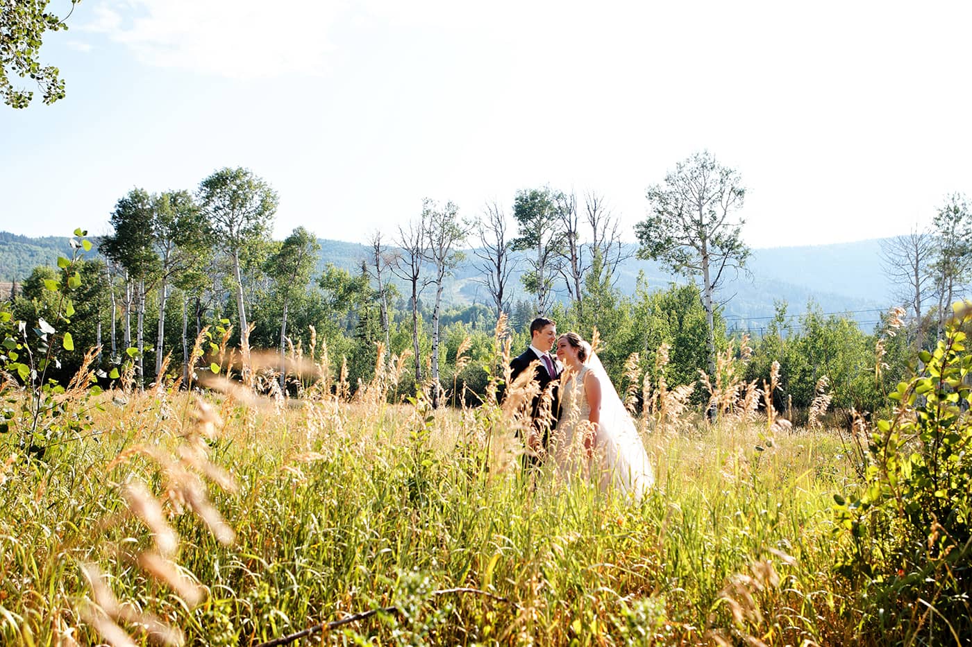 bride and groom in a grassy field.